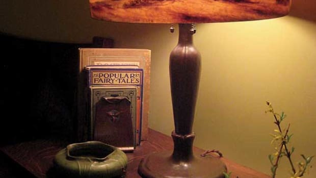 Reverse-painted scenic Handel lamp with a Grueby vase and Roycroft trillium bookends.