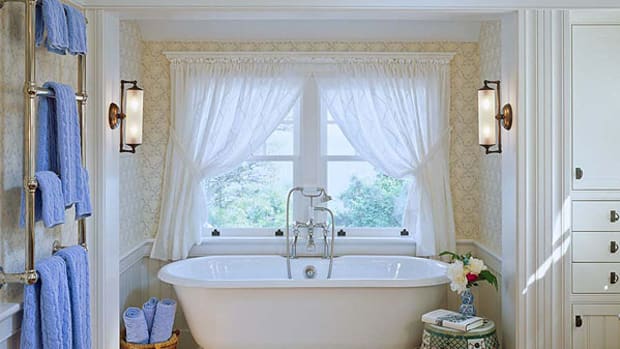 Period-friendly, well-furnished details include wallpaper, a Roman pedestal tub, and built-in storage. Photo by Brian Vanden Brink.