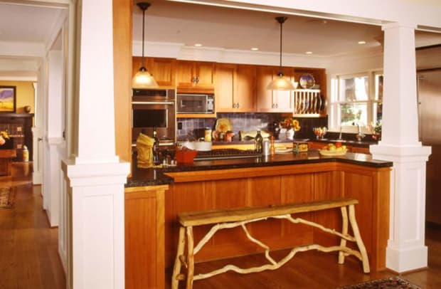 Although open to other rooms, the kitchen is separated by columns and a half-wall with built-in countertop.