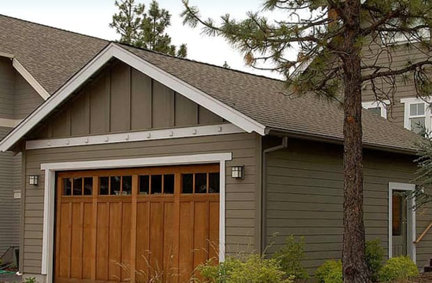 For a bungalow on a corner lot, The Bungalow Company designed an unobtrusive garage with alley access, separated by a dog-run and a patio from the main house.