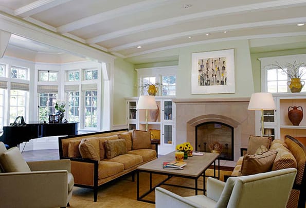 Paneled wainscot continues into the living room with its elegantly curved ceiling. The fireplace flanked by bookcases and high windows is characteristic of many Arts & Crafts houses.