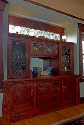 In the dining room, the built-in buffet has leaded-glass doors and rugged wood pulls.