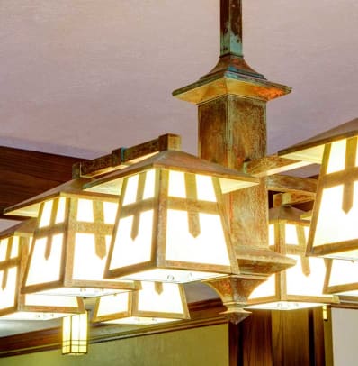Reproduction lighting has a patinated finish.