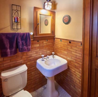 The upstairs powder room has a salvaged 1920 sink, original medicine cabinet, and tile from Clay Squared.