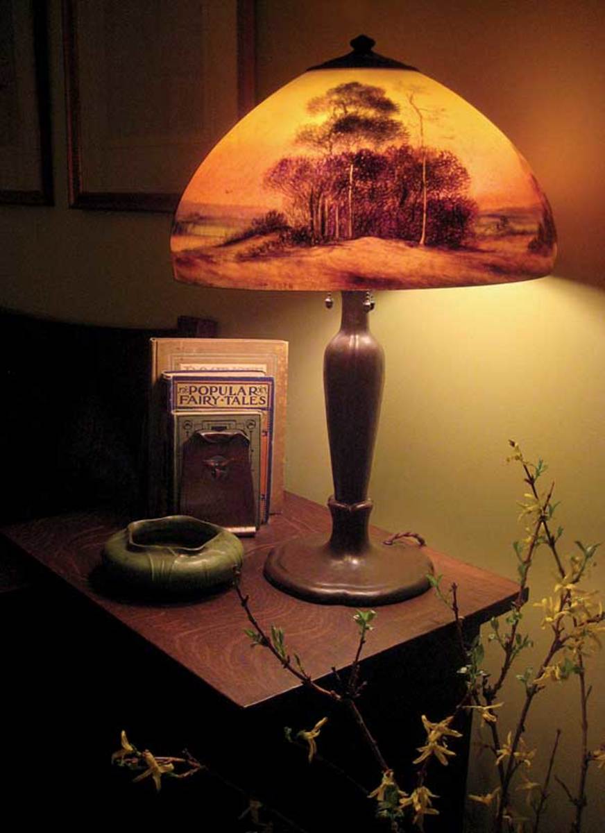 Reverse-painted scenic Handel lamp with a Grueby vase and Roycroft trillium bookends.