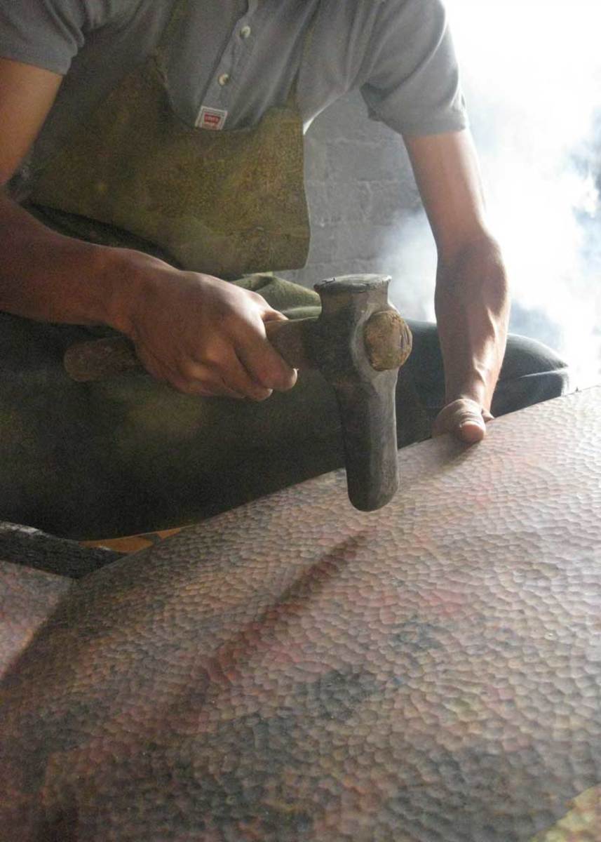 An artisan in Mexico, one of thousands cultivated by Native Trails all over the world, hammers copper by hand.