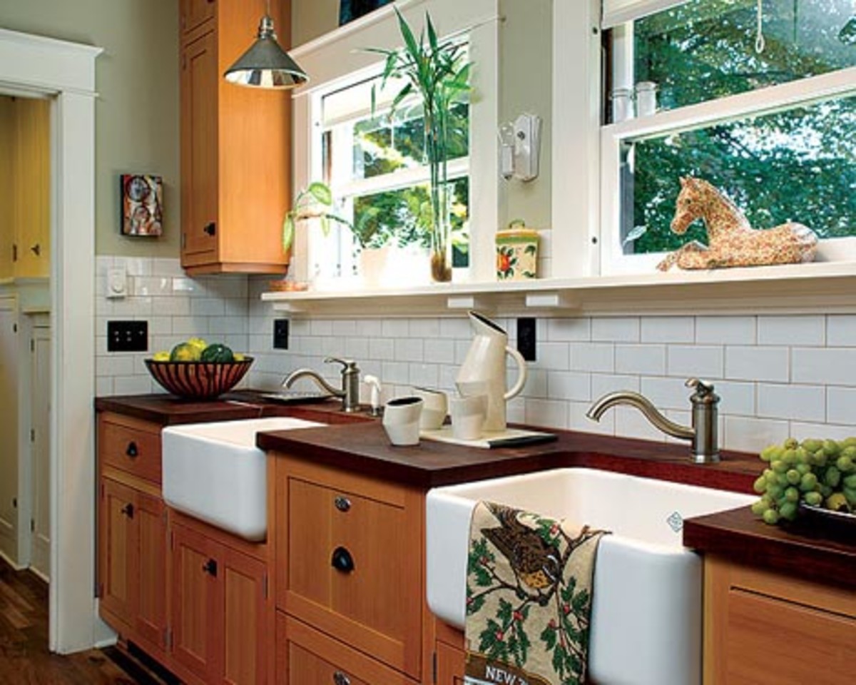 Fir cabinets join mahogany countertops and a backsplash of subway tiles. A pair of farmhouse sinks was installed under the windows with a dishwasher hidden in between.