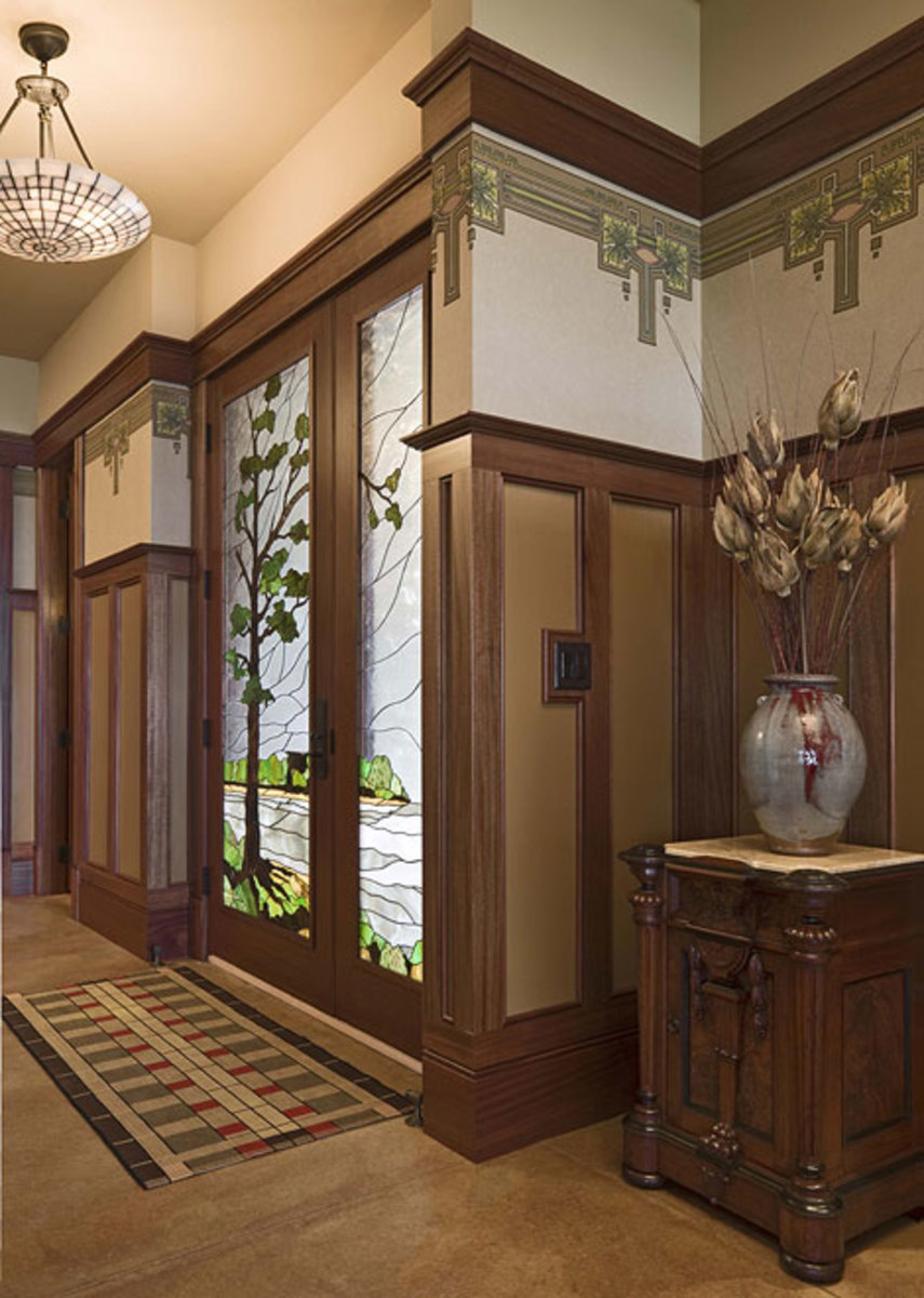 Custom home-builders Mike and Susan Hoien created a house of timeless design for themselves in Iowa. The entry features custom art glass with an oak-tree motif.