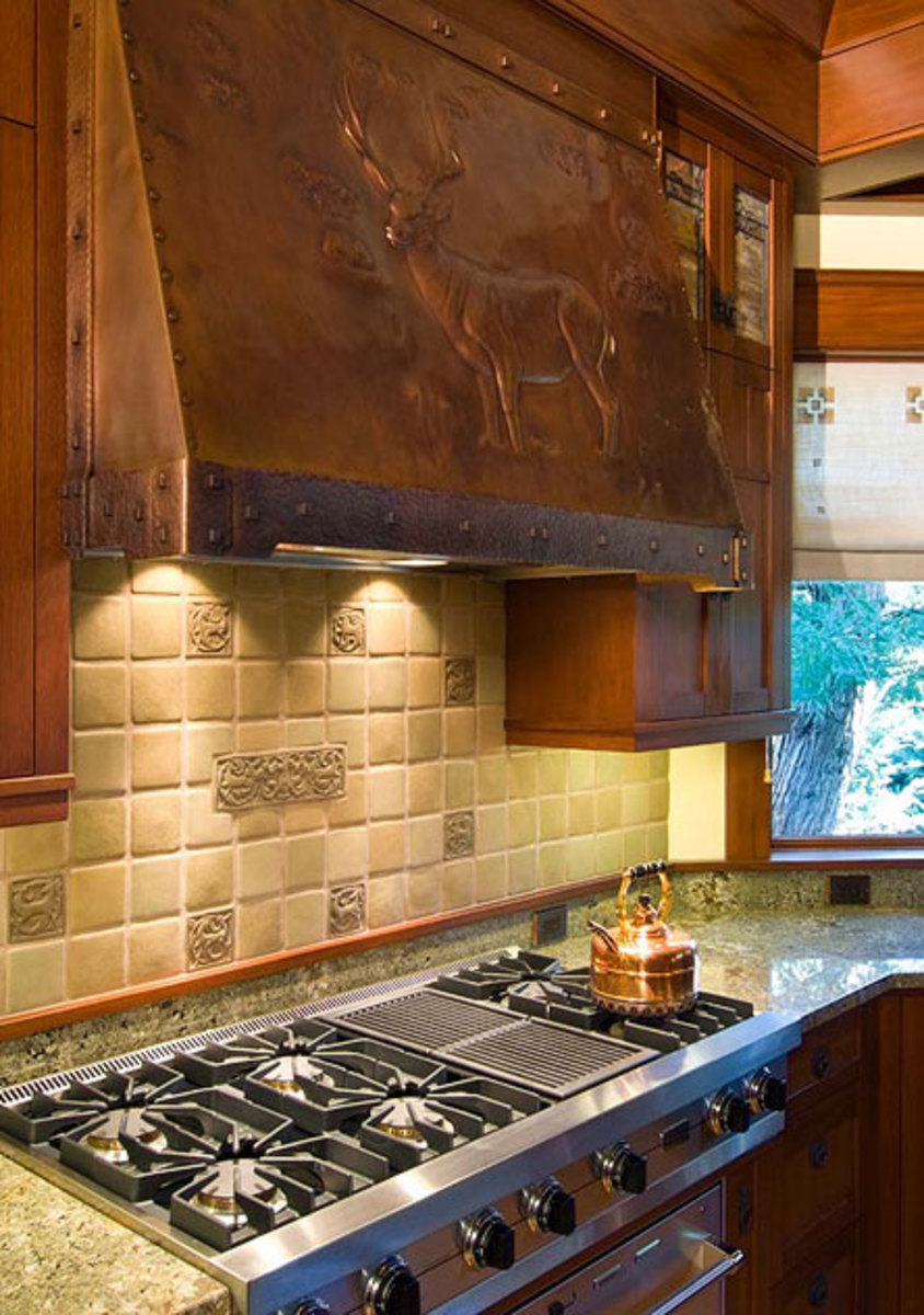 The 200-pound copper range hood is by Joseph Mross of Archive Designs. A deer theme continues on custom-made tiles by Laird Plumleigh.