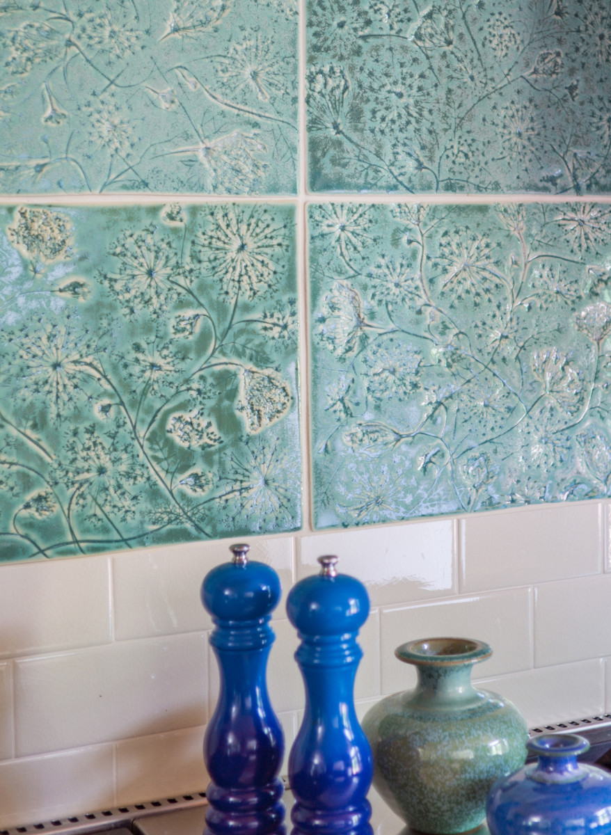 Aquatic-green accent tiles made by the homeowner tie together an Arts & Crafts philosophy with her interest in edible and medicinal plants. She pressed Queen Anne’s lace into the wet clay to create the relief pattern.