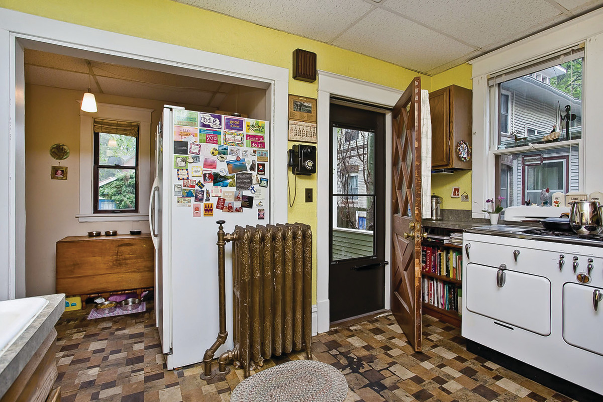 Before renovation, the kitchen was a jumble of prior remodelings, with poor placement of appliances and a radiator in the middle of the room.