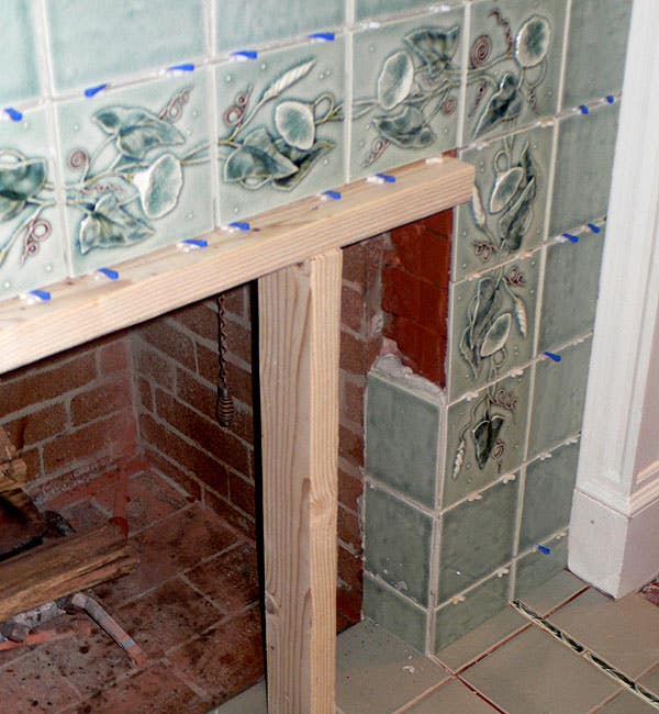 the-center-row-of-deco-tiles-is-supported-as-they-set-on-a-scaffold-built-to-just-the-right-height-bedded-with-plenty-of-mortar-a-one-tile-deep-return-lines-up-with-hearth-tile-for-a-neat-finish.jpg