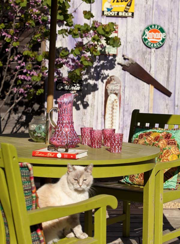 patio-furniture-from-a-local-source-isnt-teak-so-it-got-a-coat-of-ace-hardware-paint-the-color-is-asparagus-vintage-signs-hang-on-the-privacy-fence.jpg