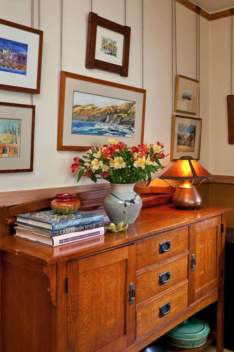 watercolors-painted-by-owner-steve-dowty-hang-above-an-oak-craftsman-style-cabinet-used-for--extra-kitchen-storage-in-the-breakfast-room.jpg