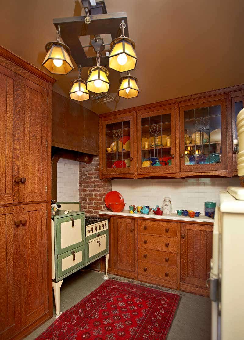 a-vibrant-dinnerware-collection-is-visible-behind-leaded-glass-cabinet-doors-light-fixtures-are-period-and-the-vintage-stove-works-fine.jpg