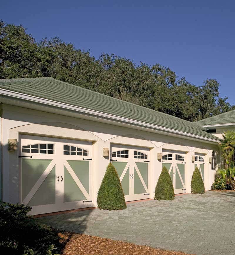 these-paint-grade-amarr-doors-roll-up-but-they-look-like-swing-out-carriage-house-doors-thanks-to-decorative-hardware-and-cross-braces-in-a-two-color-paint-scheme.jpg